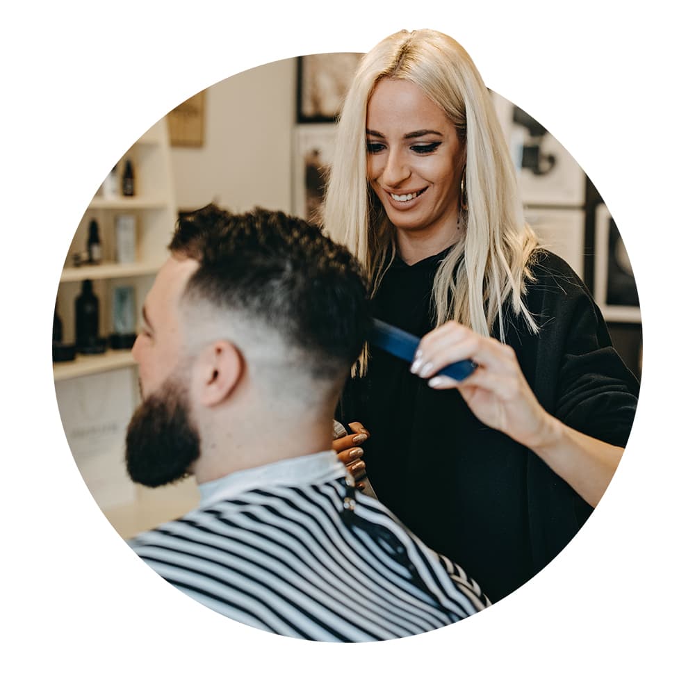 Hairstylist works with client in chair