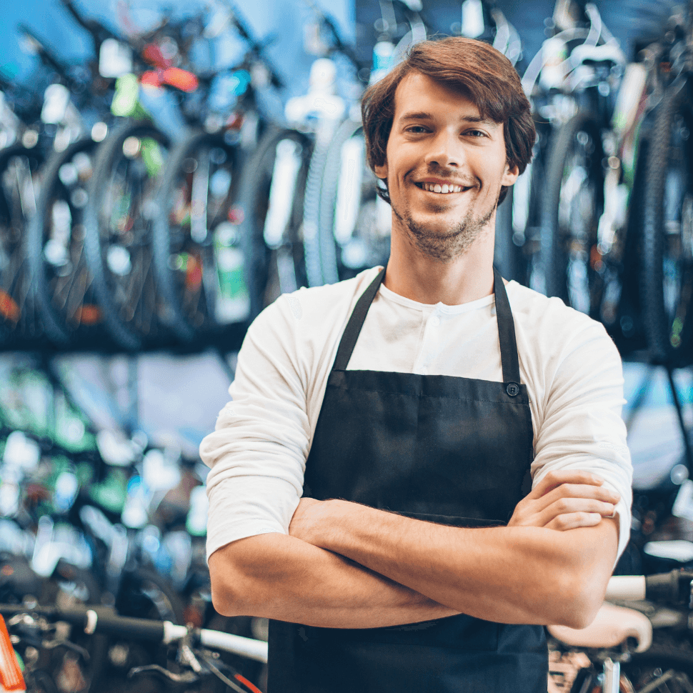 Fraud business owner image - Man wearing work apron in a bike shop