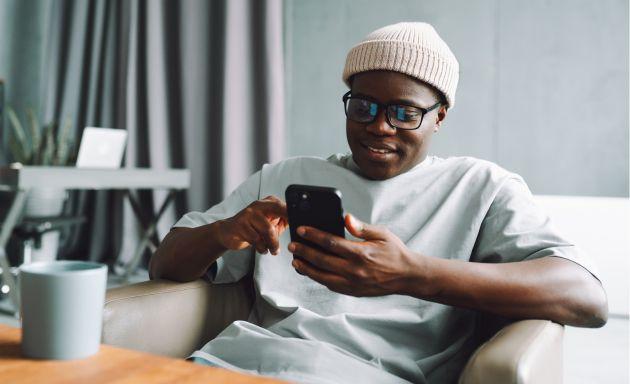 Man holding mobile phone sitting down in chair