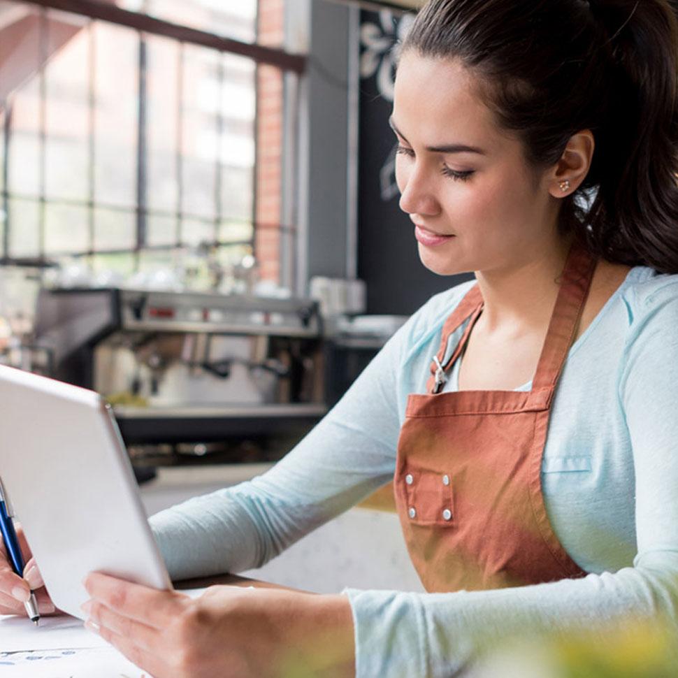 Woman working on tablet and business documents