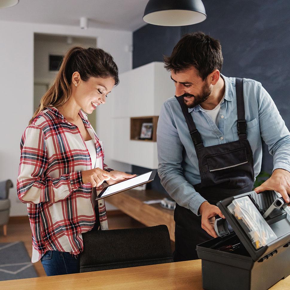 Woman paying on tablet of technician