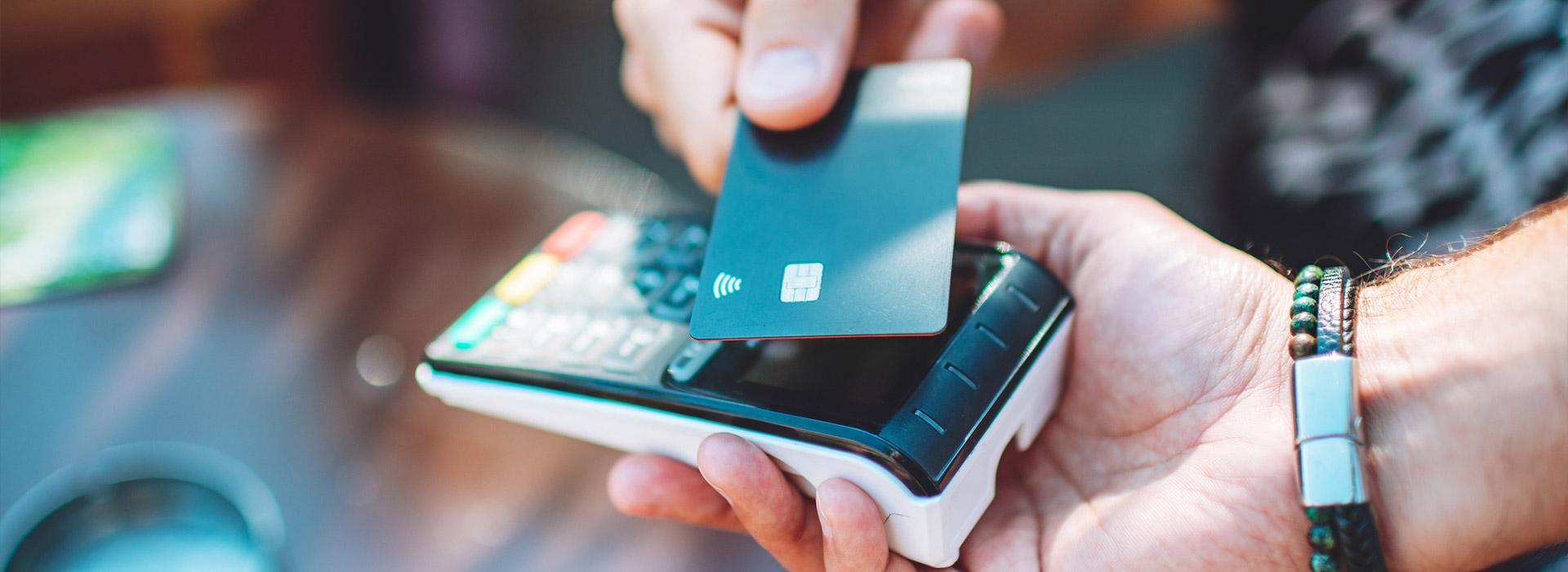 Credit card in hand while being processed - How payment processing works