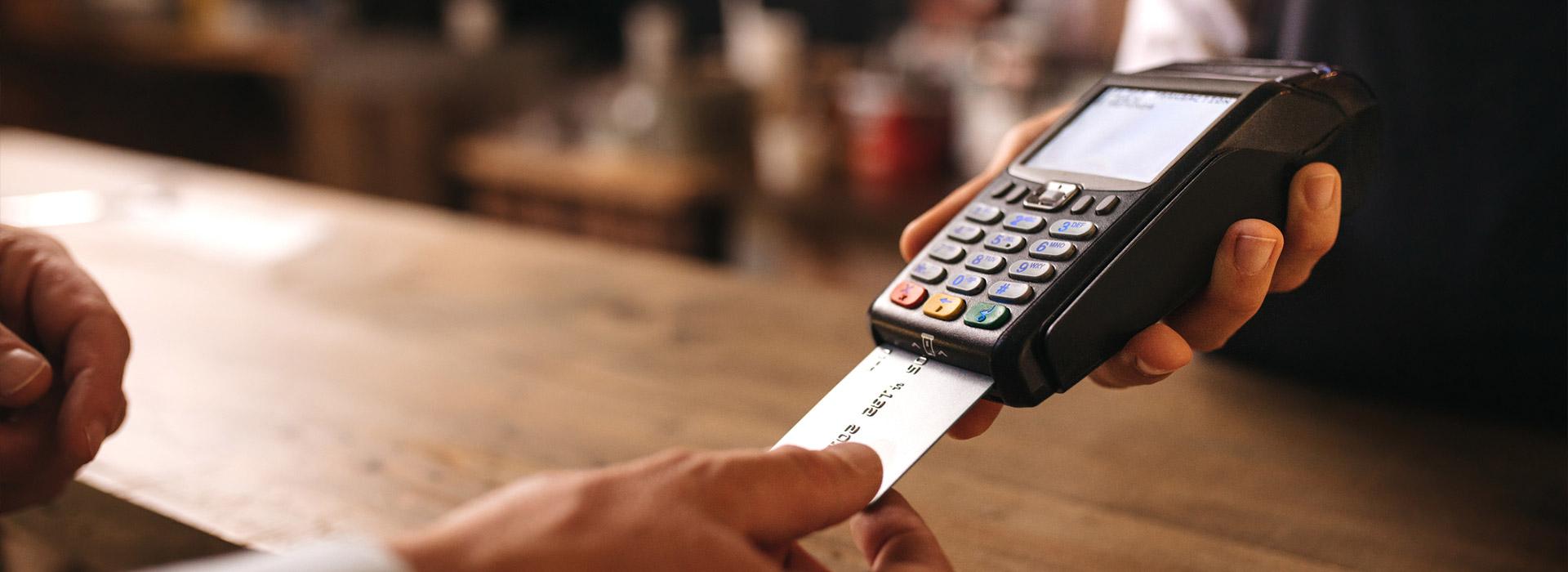 hand inserting credit card into pay terminal